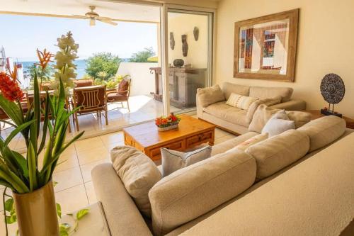 a living room with a couch and a table at Oceanview Condo in Faro de Mita in Punta Mita