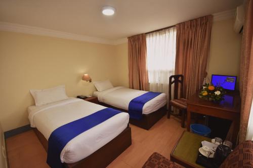 Habitación de hotel con 2 camas y TV en Pension Vasana Hotel, en Katmandú