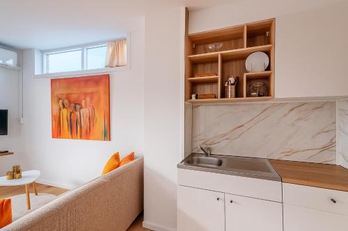 eine Küche mit Sofa und Waschbecken in einem Zimmer in der Unterkunft De Strandgaper Egmond in Egmond aan den Hoef