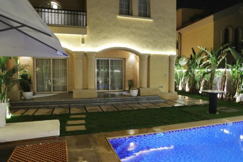 una casa con piscina en el patio en فيلا مدينتى, en Madinaty