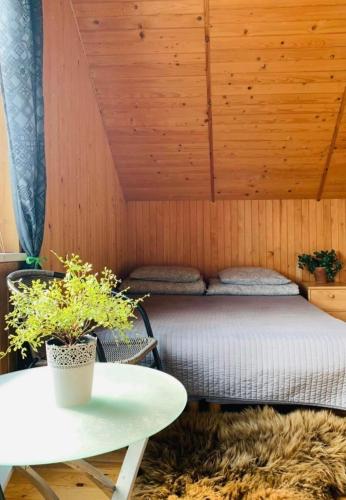 a bedroom with a bed in a wooden wall at Anykščių raj. Žalioji Stotelė in Šventupys