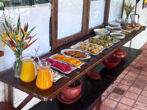 eine lange Tafel mit einem Buffet mit Speisen und Getränken in der Unterkunft Paraiso Escondido Lamas in Lamas