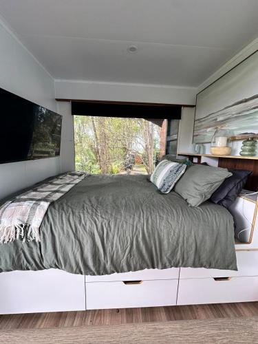 a bedroom with a large bed with a large window at Sol On Loten in Mitchells Island
