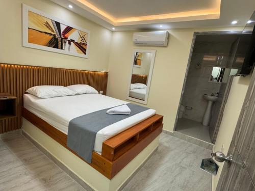 ein Schlafzimmer mit einem Bett und einer ebenerdigen Dusche in der Unterkunft Hotel Magistral Suiter in Quibdó