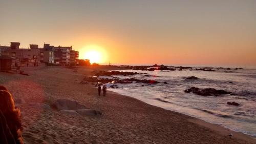 a group of people on a beach at sunset at Depto Laguna Vista Hermoso Comodo Familiar in Algarrobo