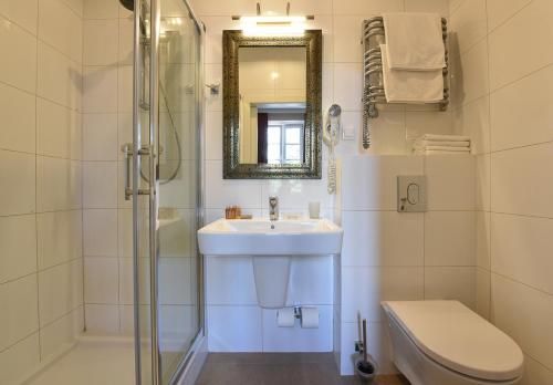 Un baño con lavabo, inodoro y espejo. en SLEEPWELL NOWY ŚWIAT - entrance from Ordynacka 14St, through the courtyard, en Varsovia