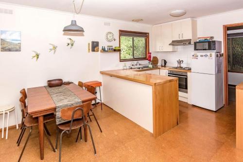 Sandy Pointにある18 Harbour View Sandy Pointのテーブルと冷蔵庫のあるキッチンとダイニングルーム