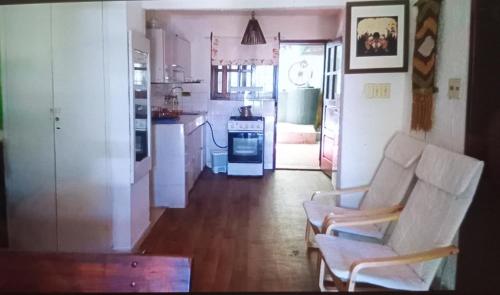 a living room with two chairs and a kitchen at Lunita in Costa Azul
