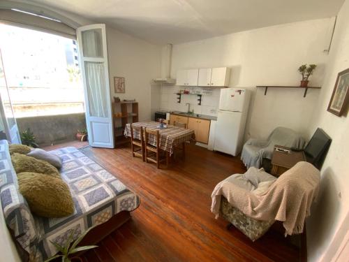 Una sala de estar con un sofá y una cocina. en Charrúa3, en Montevideo