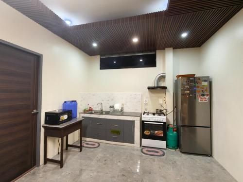 a kitchen with a stainless steel refrigerator and a stove at Davao City Cozy Home in Davao City