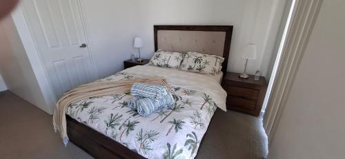 KelmscottにあるRelaxing Lake side Residence with private ensuiteの木製のヘッドボードが付いたベッドのある寝室