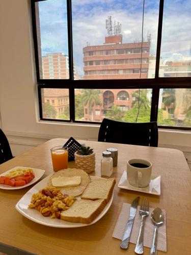 a table with a plate of breakfast food on it at Hotel Plaza Mayor 44 in Medellín