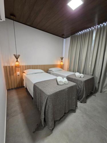 una habitación de hotel con dos camas y dos mesas en Portal do Kite, en Barra Grande