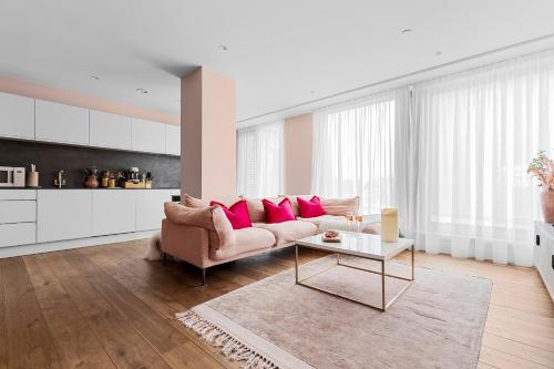 a living room with a pink couch and a table at Lux City Centre,Parking on Request,Riverside,Wifi,Netflix,2BD-ensuite,Bosch Coffee Machine in York