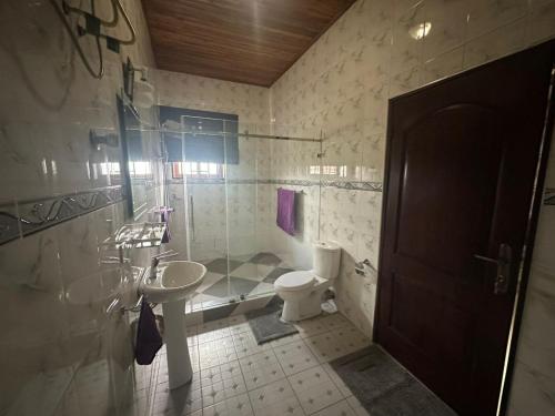 a bathroom with a sink and a toilet and a shower at Mirlees Court Homely Inn in Accra