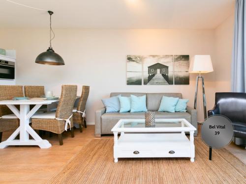 宾茨Ostsee-Traumferienwohnungen Bel Vital mit Meerblick, Balkon und Sauna的客厅里有一张沙发和一张桌子。