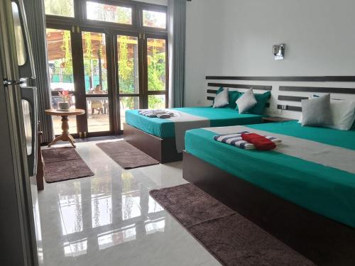 a bedroom with two beds and a window at Indunil place hiriketiya with pool in Dickwella