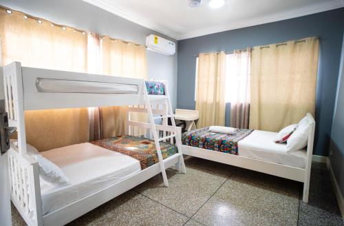 Un dormitorio con dos literas y un escritorio. en Brannic Lodge, en Accra