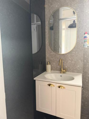 een badkamer met een witte wastafel en een spiegel bij Paradiso Escape in Fremantle