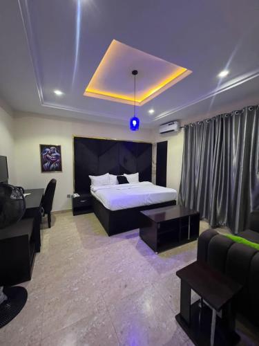 una habitación de hotel con una cama y un sofá en LEON'S HOTELS and SUITES OWERRI, en Owerri