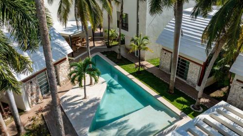 an overhead view of a swimming pool with palm trees at Casa Vela - 2BR - Where Waves Meet Relaxation in Cancún