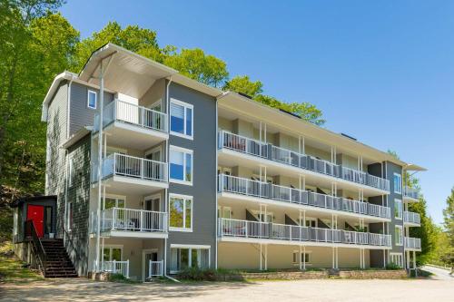 an apartment building with balconies and trees at LAO Lodge by Gestion ELITE in Mont-Tremblant