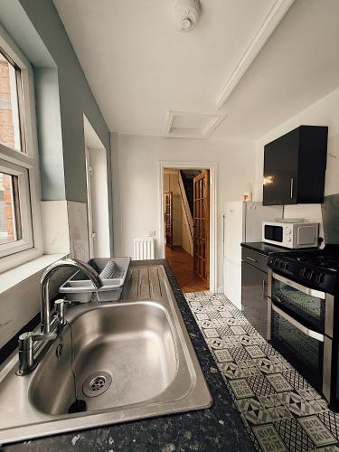 a kitchen with a sink and a microwave at Rock Ferry home in Birkenhead