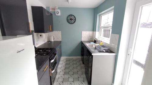 eine Küche mit Spüle und Herd in der Unterkunft Rock Ferry home in Birkenhead