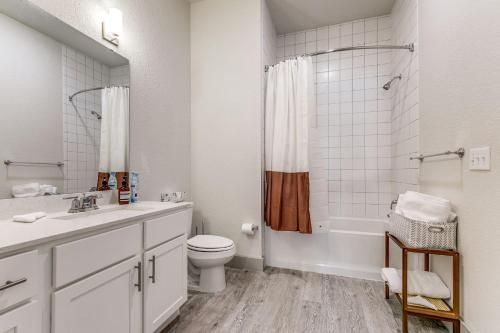 ein weißes Badezimmer mit Toilette und Dusche in der Unterkunft Riverwalk Luxury Haven Pool Free Parking in San Antonio