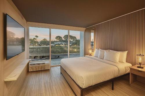 a bedroom with a large bed and a large window at Tropical Palms Hotel in Clearwater