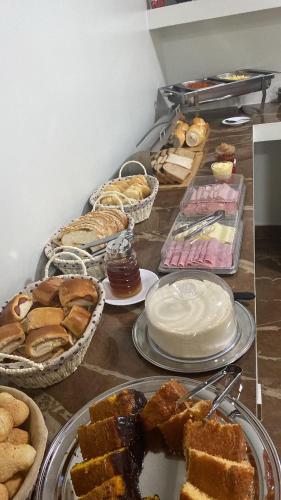 a table with many different types of bread and pastries at Aquarius Hoteis Ltda in Canarana