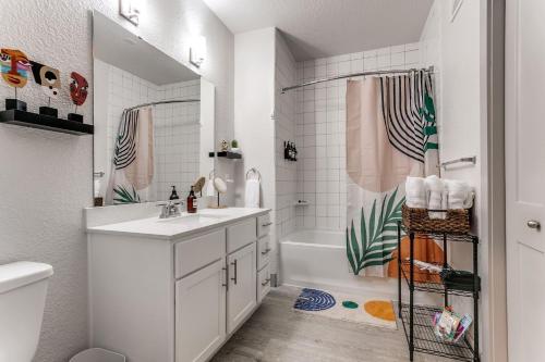 a white bathroom with a sink and a shower at Riverwalk Oasis with Riverwalk Views Free Parking in San Antonio