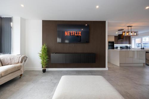 a living room with a television on a wall at Modern 5-Bed Home EV City Centre 10 min in Manchester