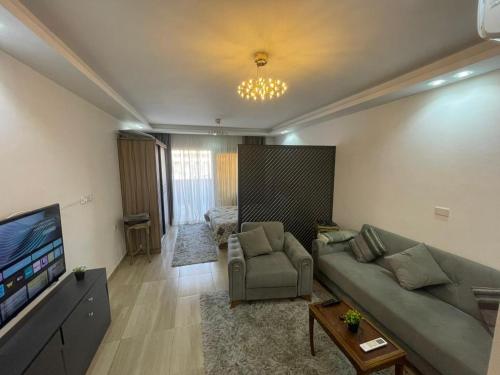 Una sala de estar con un sofá y un televisor en Alhambra Avenue, en Hurghada