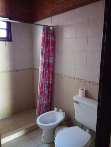 a bathroom with a toilet and a shower curtain at Quinta La Nubia in Paso de la Patria