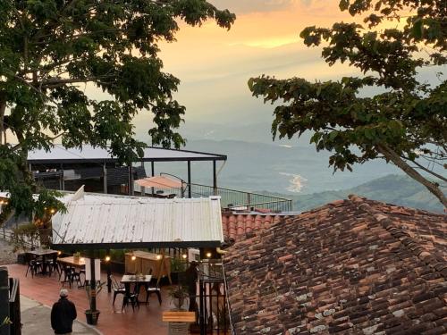 Ein Mann, der an einem Gebäude mit einem Tisch und Stühlen vorbeigeht. in der Unterkunft Hotel Boutique El Paisaje in Santa Bárbara