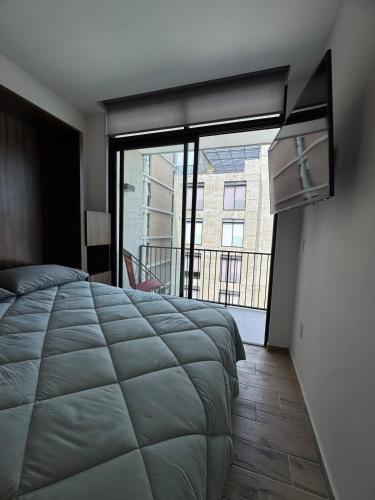 グアダラハラにあるFurnished loft in Ciudad Granja with balconyの大きなベッドと大きな窓のある寝室