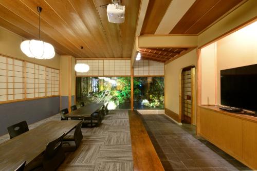 山ノ内町にあるZEN Hostelのリビングルーム(テーブル、大画面テレビ付)