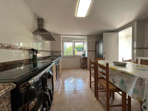 una cucina con un bancone e un tavolo con sedie di Casa Carmen e do Hilario a Ponte Do Porto