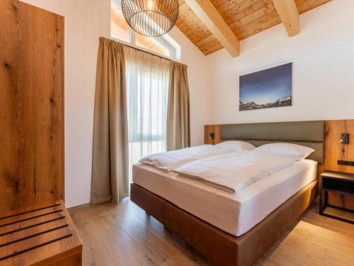 a bedroom with a large bed and a window at Grebenzen Lodge 51 in Sankt Lambrecht