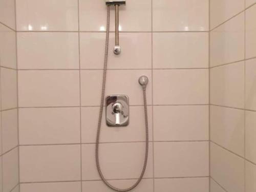 una ducha en un baño de azulejos blancos en one bedroom apartment, en Farnau