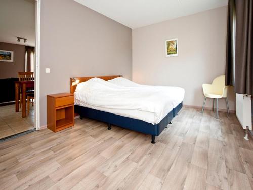 Un dormitorio con una cama, una mesa y una silla. en Charming forest house surrounded by a garden, en Heel