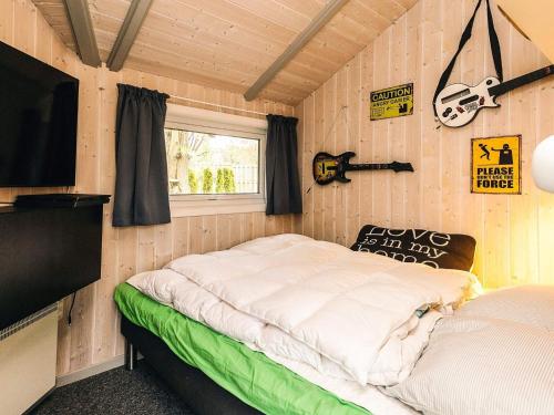 Smidstrup5 star holiday home in Gilleleje的有一张床和一台电视的房间