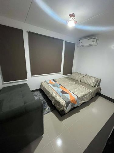 a bedroom with a bed and a couch in it at Eko's Crib Unit 30 in Sampong