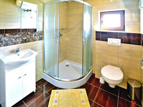 un bagno con doccia, WC e lavandino di Spacious holiday homes with terraces, Sarbinowo a Sarbinowo