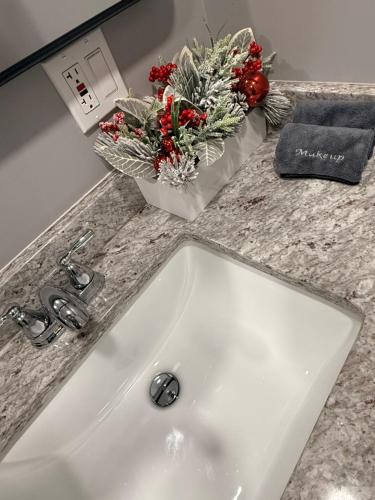 ein weißes Waschbecken mit Blumen auf einer Arbeitsplatte in der Unterkunft Bluehouse in East Chicago