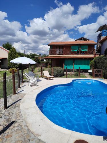 una casa con piscina di fronte a una casa di Cabañas del IntiCo a Arroyo de Los Patos
