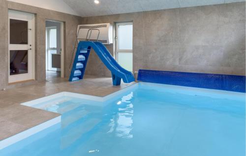 uma piscina coberta com um tobogã azul em Lovely Home In Ebeltoft em Femmøller
