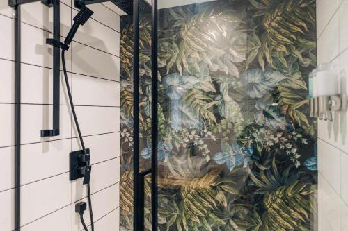 een badkamer met een muurschildering van planten op de muur bij LAO LOFT 105 by Gestion ELITE in Mont-Tremblant
