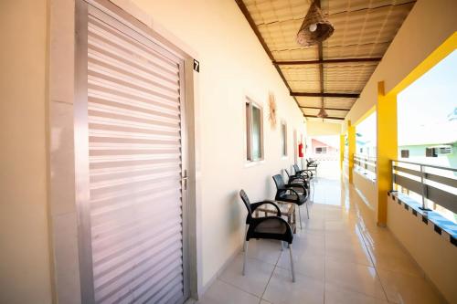 a row of chairs in a corridor of a building at Fonte dos Corais - Suíte Onda do Mar in Maragogi